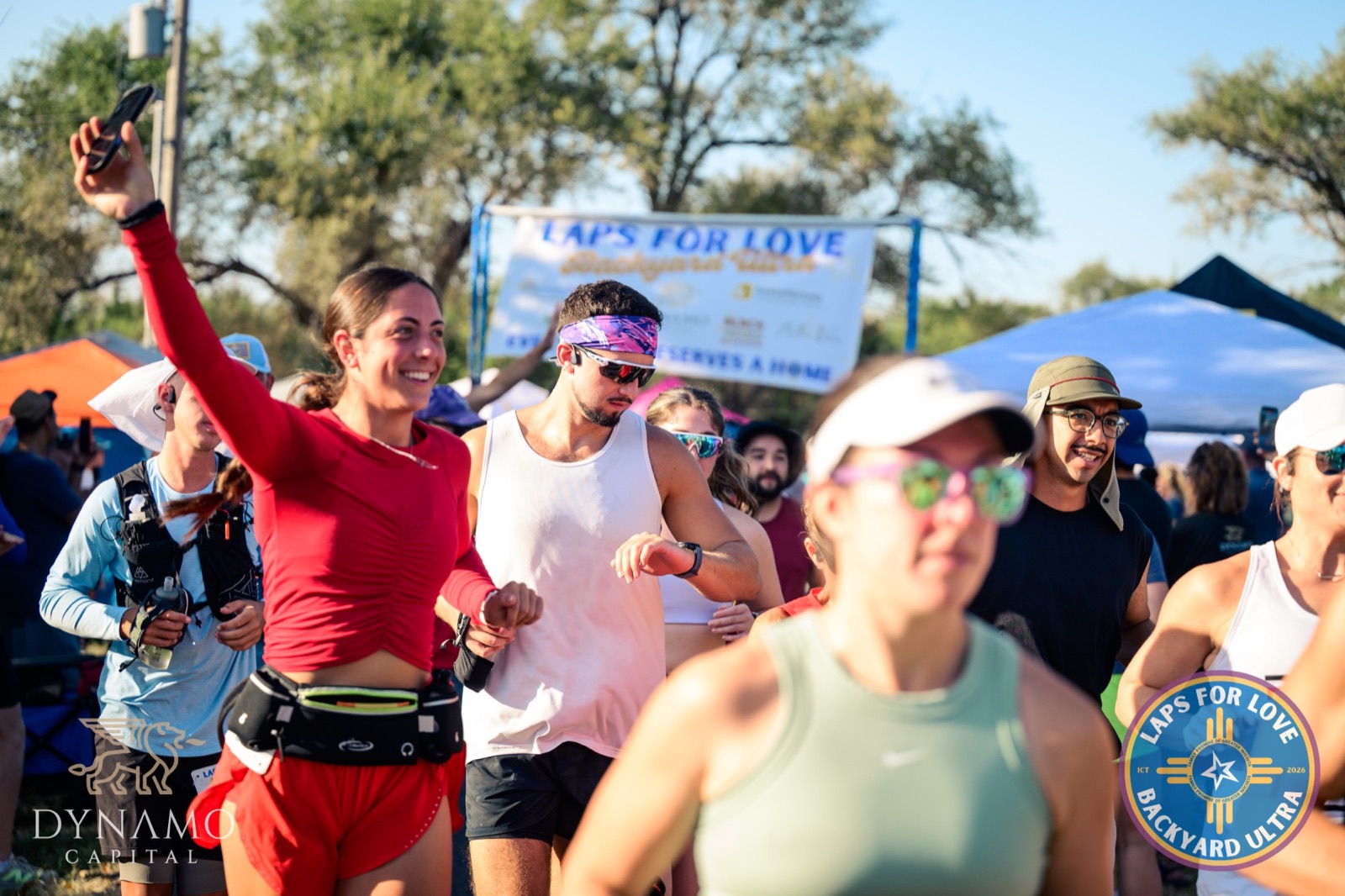 Runners waving to the crowd at the start of a loop