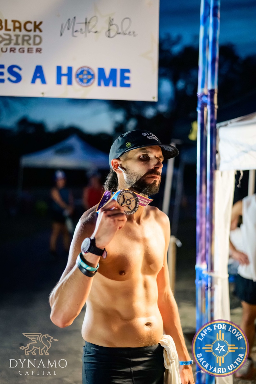 A runner with his medal after dark